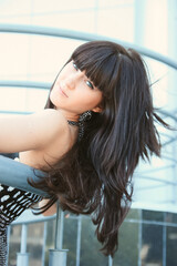 beautiful young brunette woman on the background of a modern building