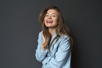 Happy young businesswoman posing isolated over black wall background. A studio shot of an adult woman standing with a smiling expression