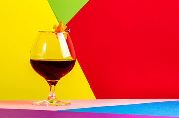 Martinique cocktail drink with golden rum, red vermouth, liqueur, bitter and orange zest. Modern style still life on creative bright multi-colored background