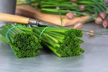 Bunches of fresh chives on the kitchen table, ready to be chopped