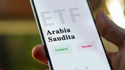 An investor analyzing an etf fund. ETF text in Spanish : Saudi Arabia, buy, sell.