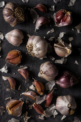 Fresh garlic bulbs and cloves grouped on black background