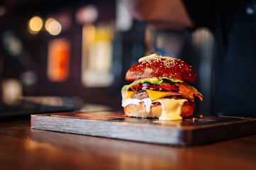 burger with meat, vegetables and cheese on table