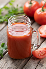 Glass of nutritious tomato juice and fresh tomatoes