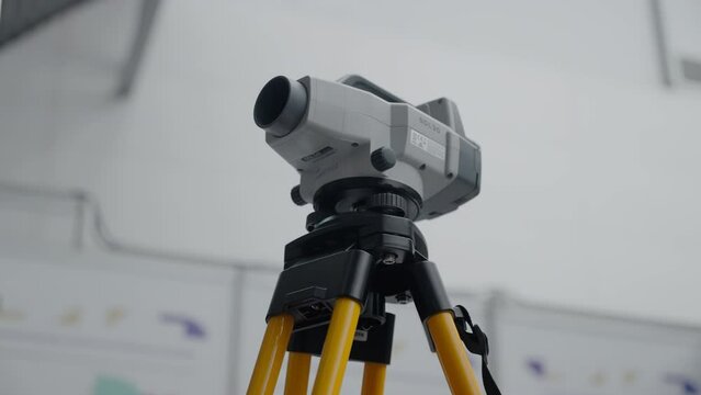 A tripod with a tool for geodesy. Exhibition equipment for measuring on the ground.