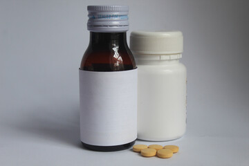 a medicinal syrup and tablets on a white background