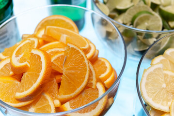 Photograph of beautiful fresh oranges and limes turned into slices prepared for cocktails. The...