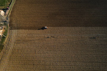 farmer driving a crawler tractor ploughing power harrowing surface crust, breaking cods to seeding...
