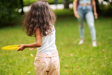 frisbee in the park, family holidays, african girl throws a disc to mom, active games with children...