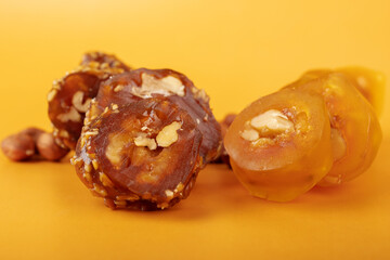 churchkhela, Nutritious snack from nuts and grape juice an orange background, copy space,banner