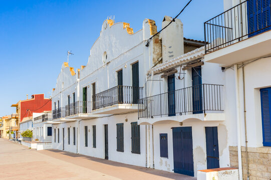 White house with blue doors at the boulevard in Comarruga, Spain