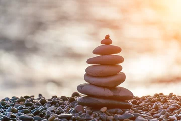  Balanced rock pyramid on pebbles beach. Golden sea bokeh on background. Selective focus, zen stones on sea beach, meditation, spa, harmony, calm, balance concept. © svetograph