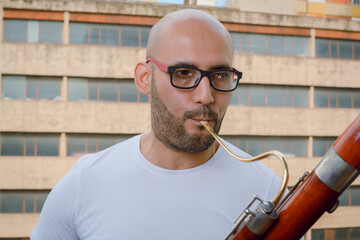 close-up portrait of man playing bassoon on apartment balcony
