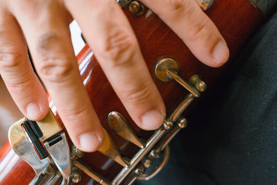 close-up of bassoonist male hand on the neckline pressing the keys