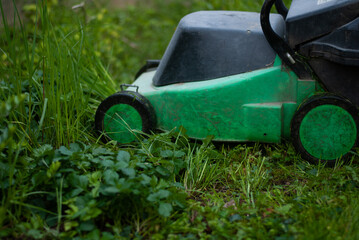 Lawn-mower on green grass in the garden
