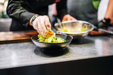 Chef cooking Caesar salad on restaurant kitchen