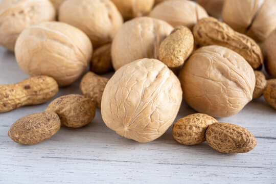 Mixed nuts on a white wooden background.