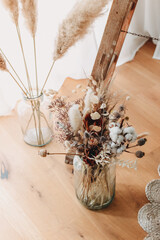 Trockenblumen in einer großen Glasvase. Boho Dekoration für Hochzeiten 