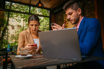 A business couple checking their phones