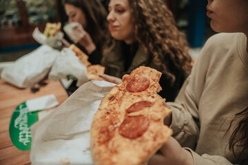Close up shot of girl holding a slice of pizza