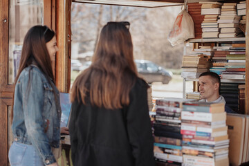 Girls talking to the book seller