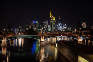 Captivating  of Frankfurt's business district skyline, a bridge illuminated by traffic, and the river with the city's reflection at night.