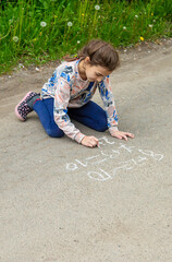 Children draw equations on the pavement with chalk. Selective focus.