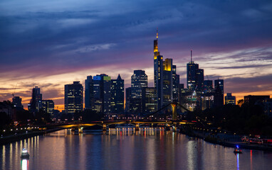 Fototapeta na wymiar Captivating of a Frankfurt's skyline at sunset, featuring a bridge, traffic, skyscrapers, and colorful reflections in the river.
