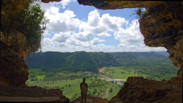 hiker overlooking natural window cave cueva ventana in arecibo puerto rico