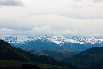 Aerial vIew of city Verhovyna by drone. Summer Ukraine Ivano Frankivsk region, West Ukraine. Carpatian mountains. Mountain peaks in the snow in summer. 