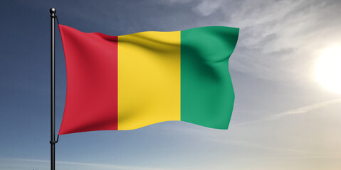 Guinea national flag cloth fabric waving on beautiful grey sky Background.