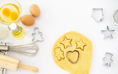 Christmas baking background with copy space for a greeting text, peace of dough rolled out for cooking Xmas gingerbreads, top down view. copy space