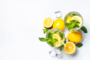 Lemonade in glass on white table. Cold summer drink top view with copy space.