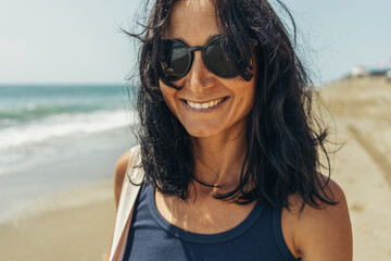 beautiful brunette girl in black glasses on the beach