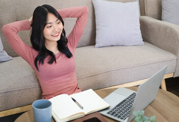 Young pleased happy cheerful cute  business woman sit indoors in home using laptop computer. Woman enjoying self-directed learning with online educational watching webinar or attending e-class .