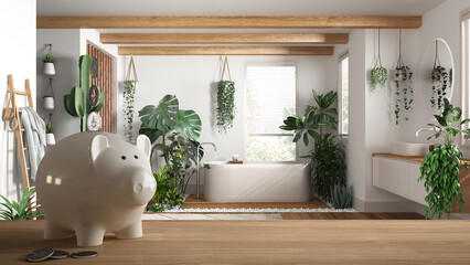 Wooden table top or shelf with white piggy bank with coins, bathroom with bathtub and many houseplants, expensive home interior design, renovation restructuring concept