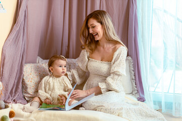 Fototapeta na wymiar Young mom reading with her one year old girl