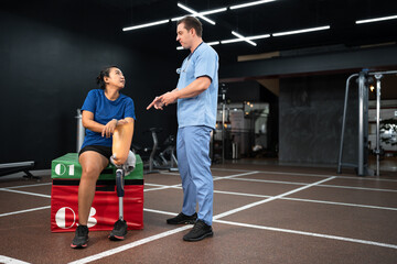 Caucasian assisted male physiotherapist take care Asia woman with prosthetic leg	