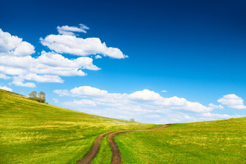 Green hills and the blue sky with clouds at spring sunny day.