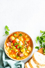 Minestrone soup, italian vegetable soup with smoked sausages, Top view with copy space.