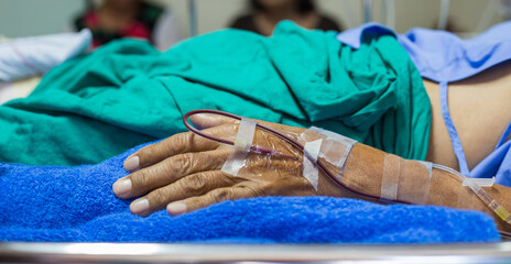 The patient recuperated in bed with an IV injected into his left hand.