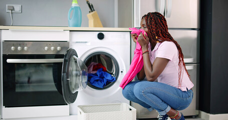 Young Woman Crouching With Cleaned Clothes