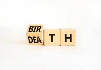 Birth or death symbol. Businessman turns wooden cubes and changes the word Death to Birth. Beautiful white table white background, copy space. Business and birth or death concept.