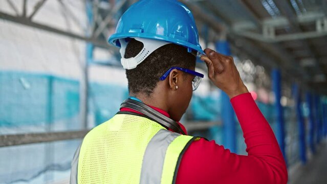 African american woman architect wearing hardhat at street