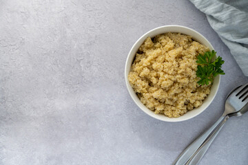 Cooked quinoa in white bowl, healthy food, top view, copy space