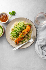 Healthy food, quinoa with baked red fish salmon served with fresh cucumber, top view