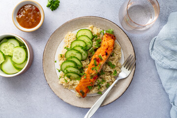 Healthy food, quinoa with baked red fish salmon served with fresh cucumber, top view