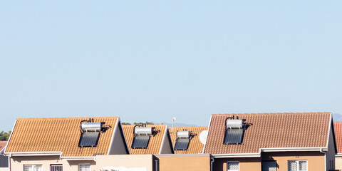 Rooftop solar hot water geysers on houses in a lower income housing estate. Affordable sustainable...