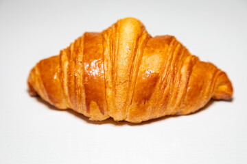 Golden brown butter croissant with shadow isolated on the plain background.