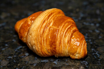 Golden brown butter croissant with shadow isolated on the plain background.